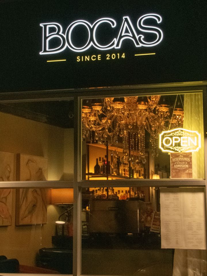 The illuminated BOCAS Since 2014 sign above the lit front window in Aguadilla at night