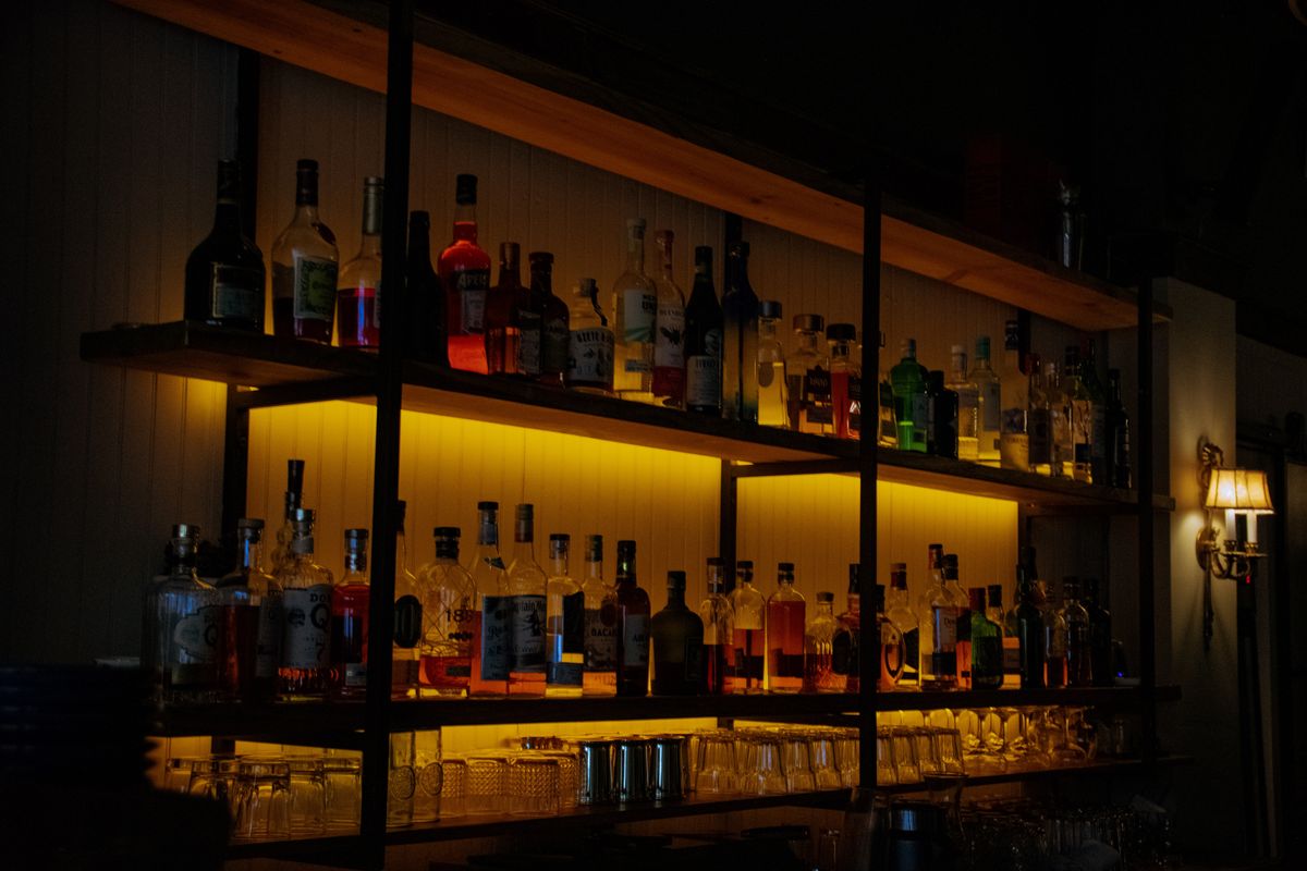 The backlit bar at Restaurante Bocas, shelves of spirits glowing above the counter