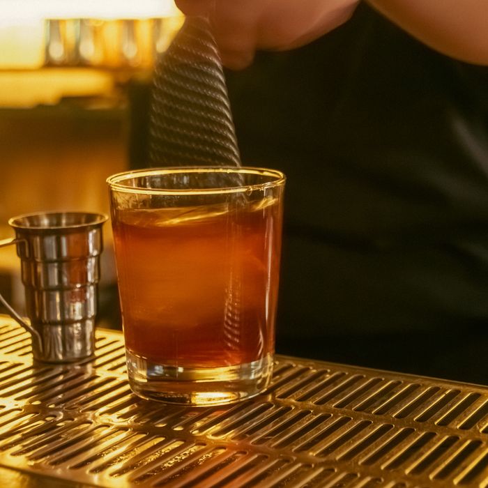 A bartender stirring an amber cocktail over ice on the bar at Restaurante Bocas